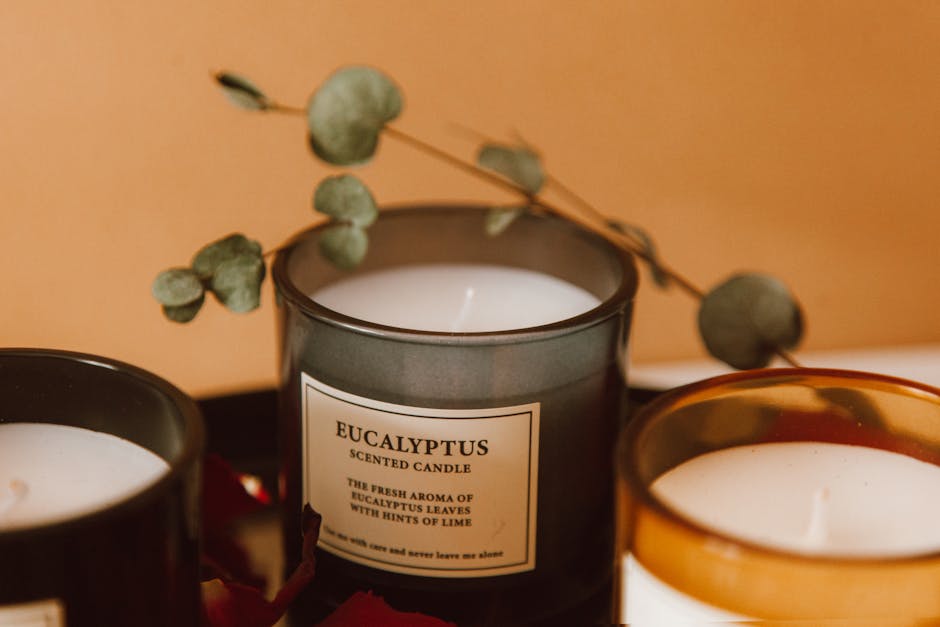Velas aromáticas de eucalipto con hojas secas sobre una mesa de madera